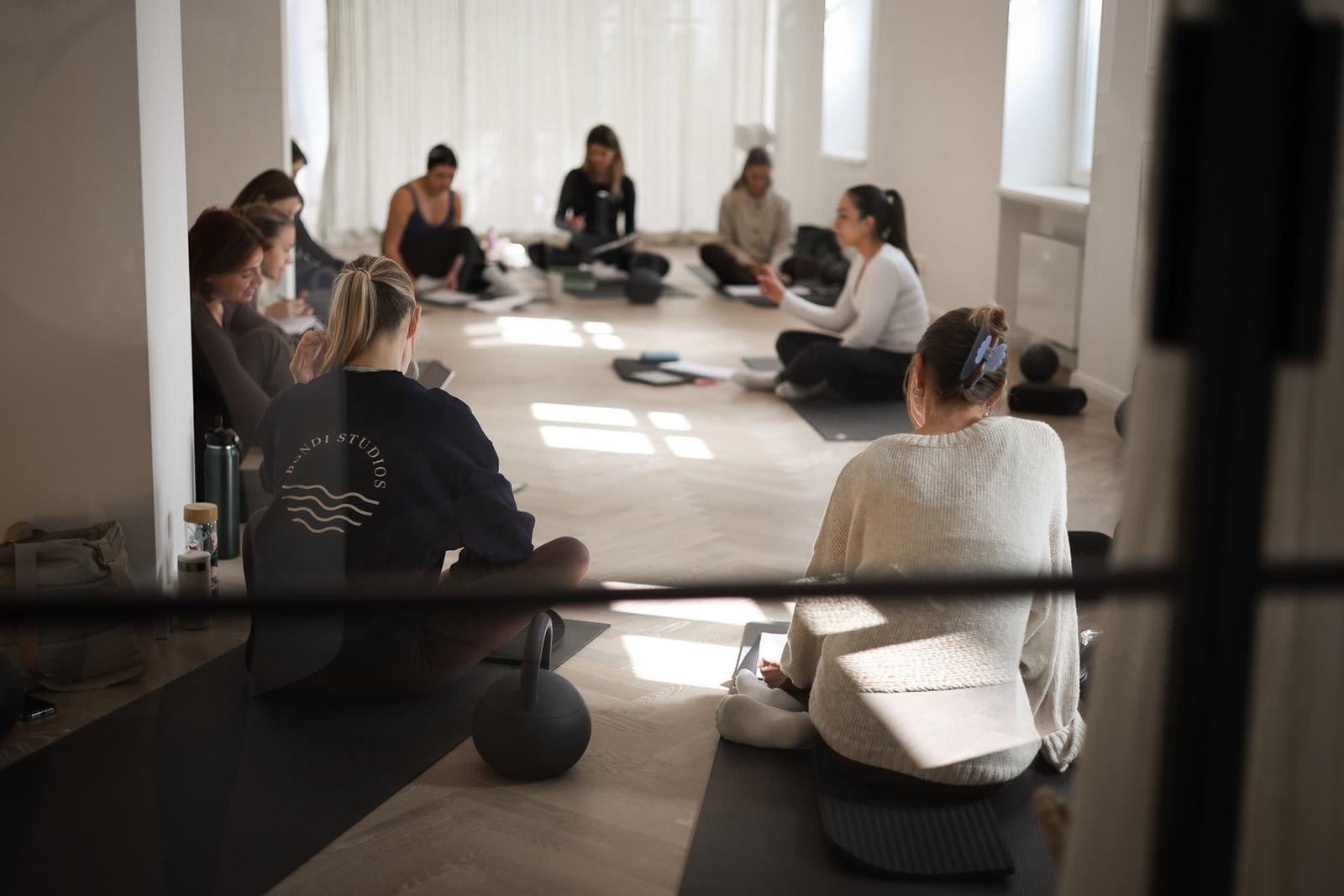 Instructor coaching a student on Pilates studio equipment at a Body Form Education intake